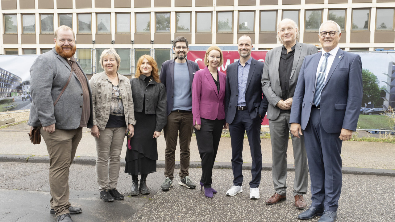 Auf dem Foto stehen die Hochschulpräsidentin Prof. Dr. Dorit Schumann (Mitte), rechts neben ihr Wissenschaftsminister Clements Hoch, der Dekan des Fachbereichs Gestaltung Prof. Dr.-Ing. Matthias Sieveke und der Leiter der LBB-Niederlassung Trier, Dr.-Ing. Wilfried Hoffmann. Die Stadt Trier vertrat ihr Kulturdezernent Markus Nöhl. Er steht links.