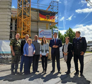 Vor dem Gebäude mit Richtkranz stehen von links: Oberst Knuth Pfeiffer (Bundesamt für Infrastruktur, Umweltschutz und Dienstleistungen der Bundeswehr – BAIUDBw -),Manfred Hill, Leiter der LBB-Niederlassung Koblenz, Elena Kraus (Stv. Geschäftsführerin Landesbetrieb LBB), Generalarzt Dr. med. Jens Diehm (Kommandeur und Ärztlicher Direktor Bundeswehr-Zentralkrankenhaus Koblenz), Janine Färber (Abteilungsleiterin im Amt für Bundesbau Rheinland-Pfalz), Thomas Hitschler (Parlamentarischer Staatssekretär beim Bundesminister der Verteidigung), Nancy Sprock-Mahlo (Leiterin des Kompetenzzentrums Baumanagement Wiesbaden des BAIUDBw) und Oberstarzt Prof. Dr. med. habil. Robert Schwab.