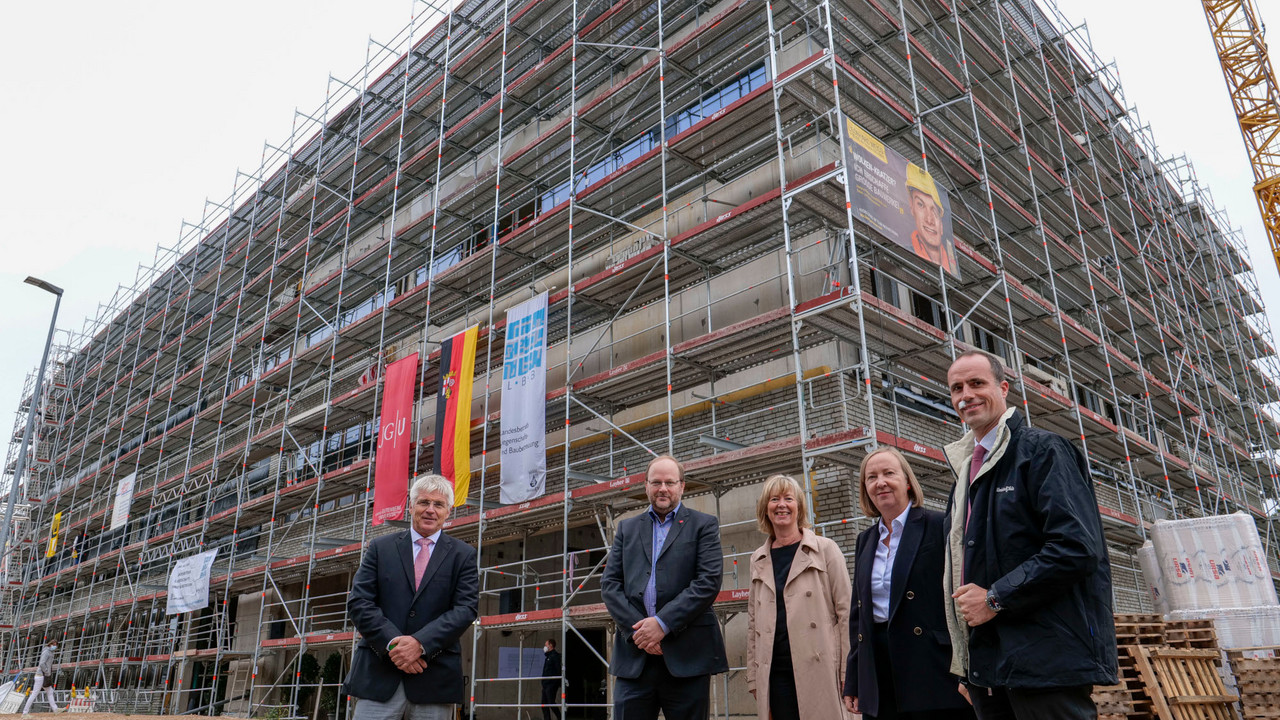Das Bild zeigt (von links) Holger Basten, Geschäftsführer des Landesbetriebs LBB, Prof. Dr. Volker Büscher vom Institut für Physik, Finanz- und Bauministerin Doris Ahnen, JGU-Kanzlerin Dr. Waltraud Kreutz-Gers und Wissenschaftsminister Clemens Hoch vor dem eingerüsteten Forschungsneubau.