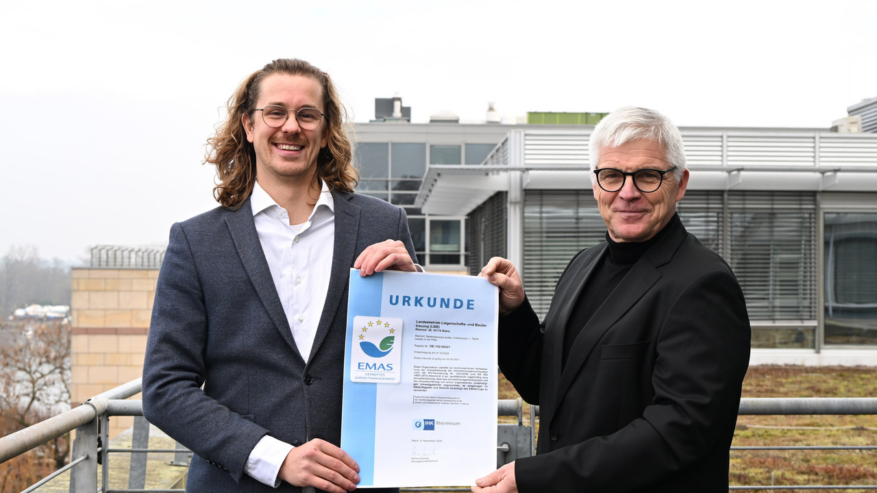 Umweltmanagementbeauftragter Fabian Wichtrup und LBB-Geschäftsführer Holger Basten präsentieren auf der Dachterrasse der Zentrale die EMAS-Urkunde.